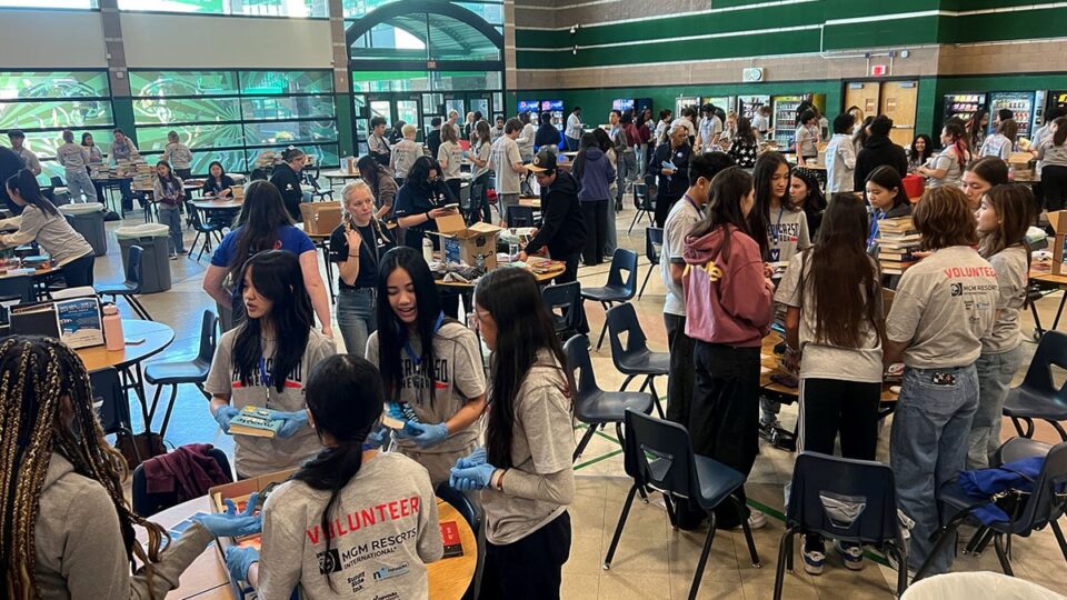 Volunteers arranging books into organized sections for donation