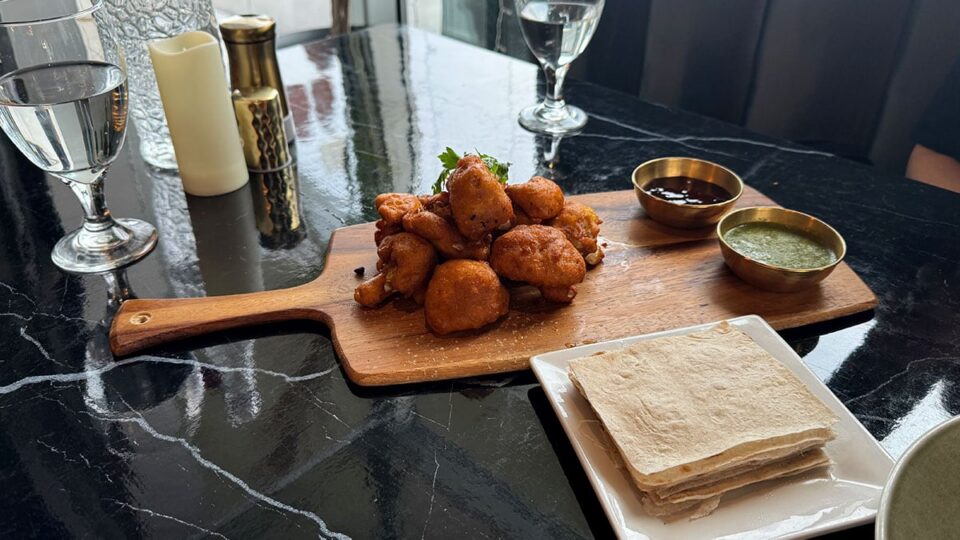 Crispy cauliflower pakora fritters served with chutney dipping sauces at Rumi Room