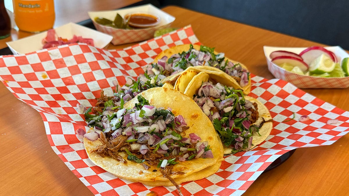 Birria tacos at Tacos Los Barrios served on tortillas with traditional toppings.