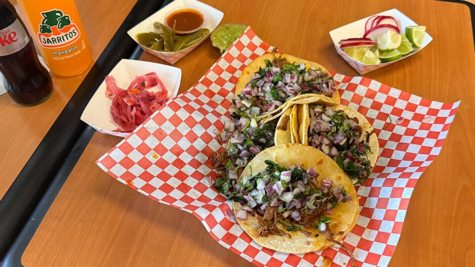 Close-up of birria tacos with red onion and cilantro at Tacos Los Barrios in Las Vegas.