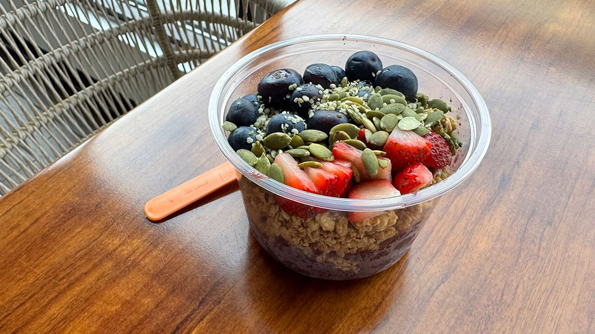 acai bowl with granola strawberries blueberries seeds and almond butter