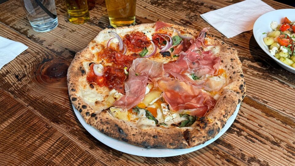 Half and half Neapolitan pizza with brie and apricot on one side and pear jalapeño on the other at Settebello