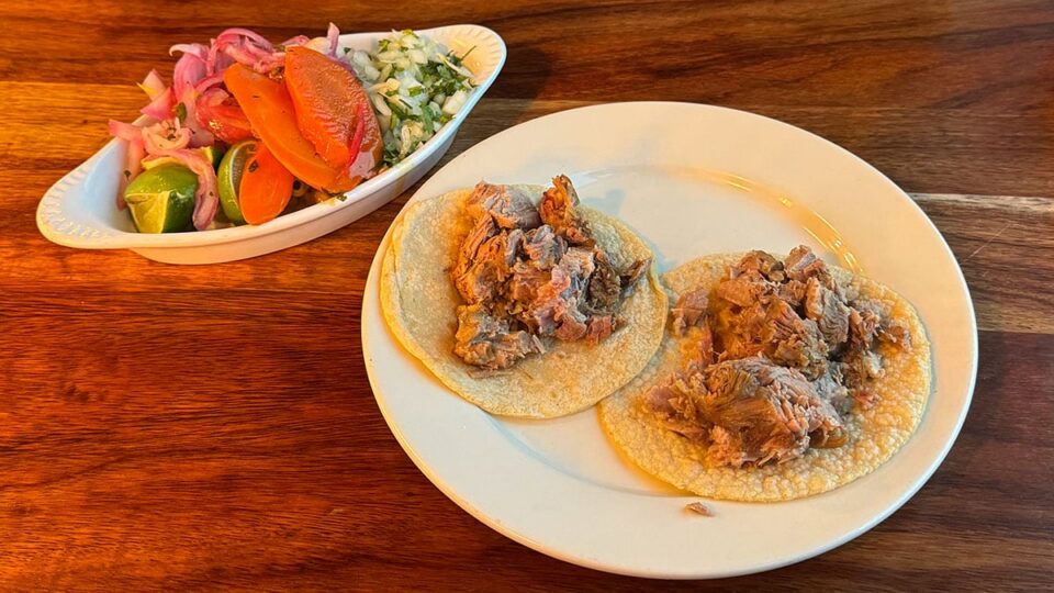 Carnitas tacos topped with cilantro and onions at Carnitas y Tortas Ahogadas Guadalajara