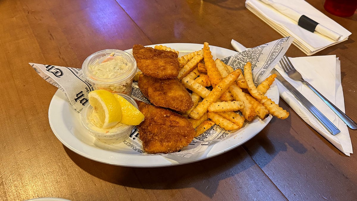 Plate of fish and chips at Jonny Mac’s Water Street Tavern featuring crispy battered fish, golden fries, and a side of dipping sauce.