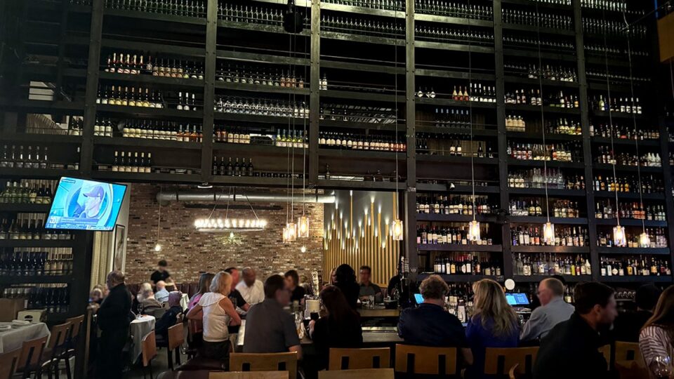 Floor-to-ceiling wine wall display behind the bar at Grape Street Café Wine Bar