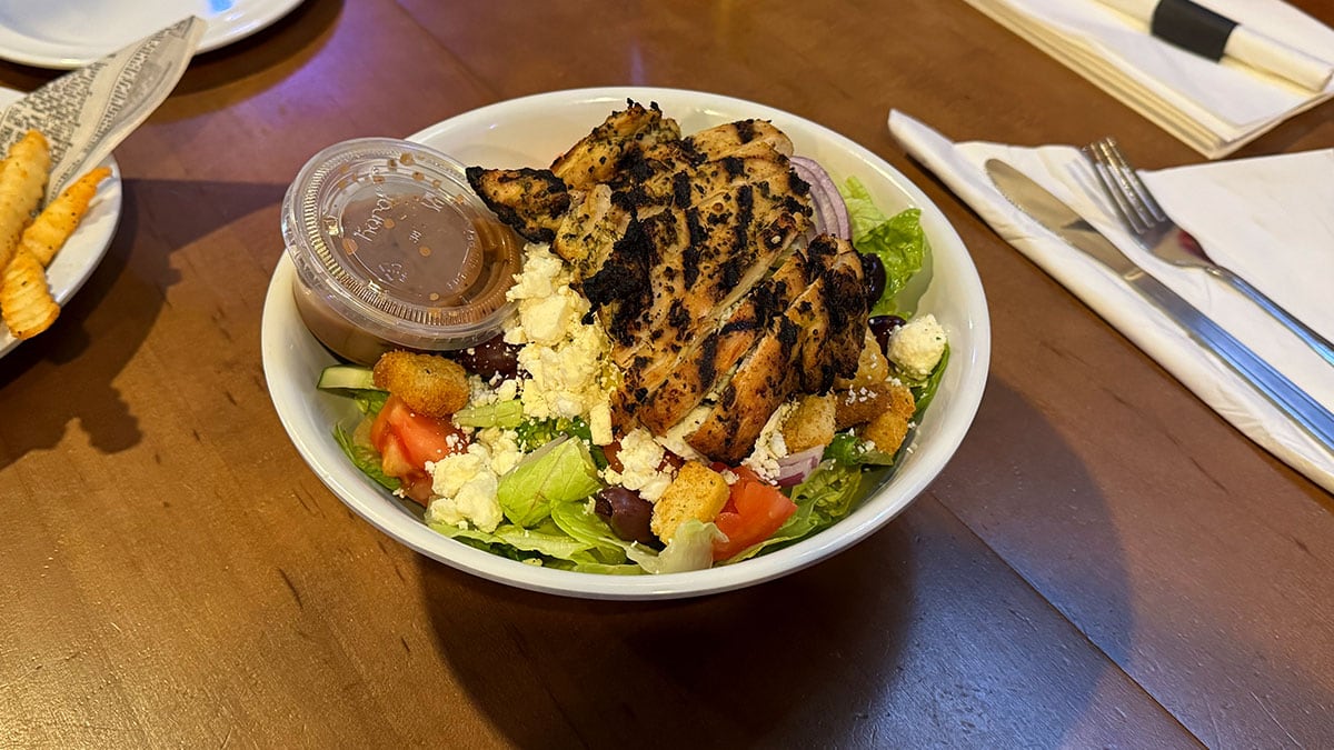 Fresh Greek salad at Jonny Mac’s Water Street Tavern with crisp lettuce, tomatoes, cucumbers, olives, and feta cheese.