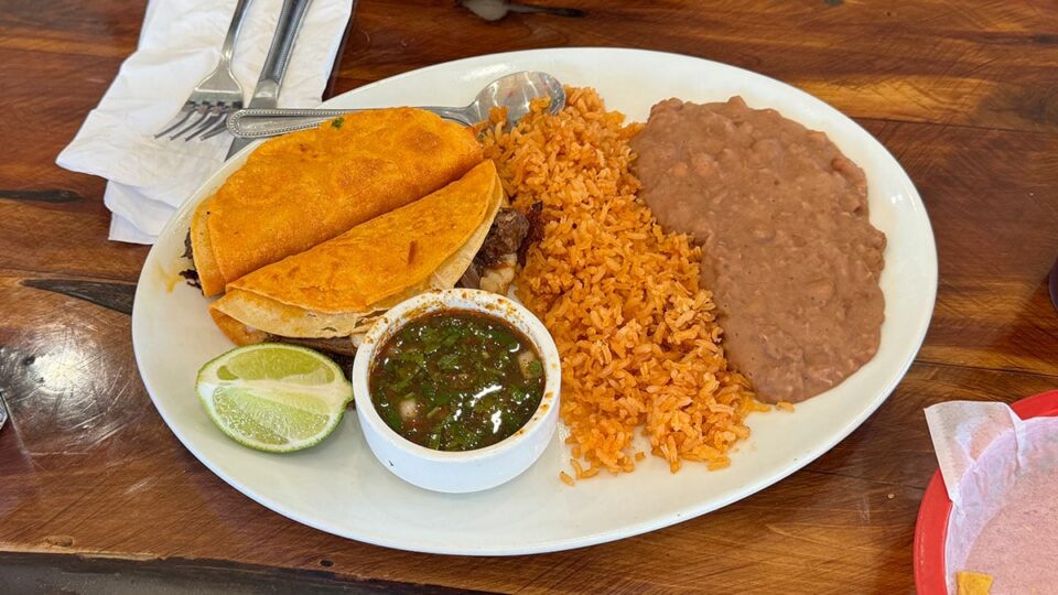 Quesabirria tacos served with rice, beans, and consommé at El Zarape Family Restaurant.