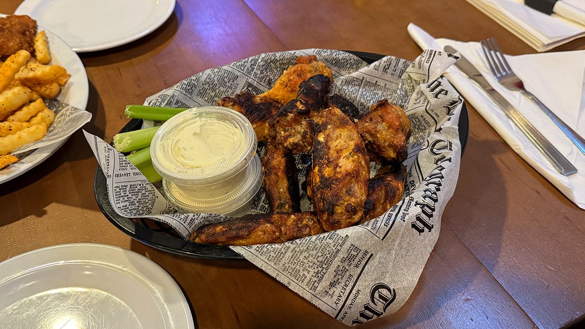 Close-up of the famous double baked chicken wings at Jonny Mac’s, crispy on the outside and coated in flavorful sauce.