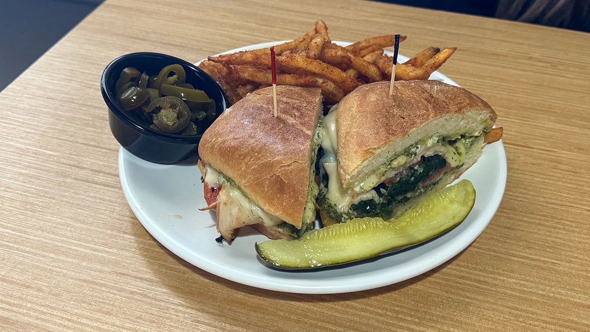 turkey pesto sandwich with vegetables and side of fries at The Cracked Egg