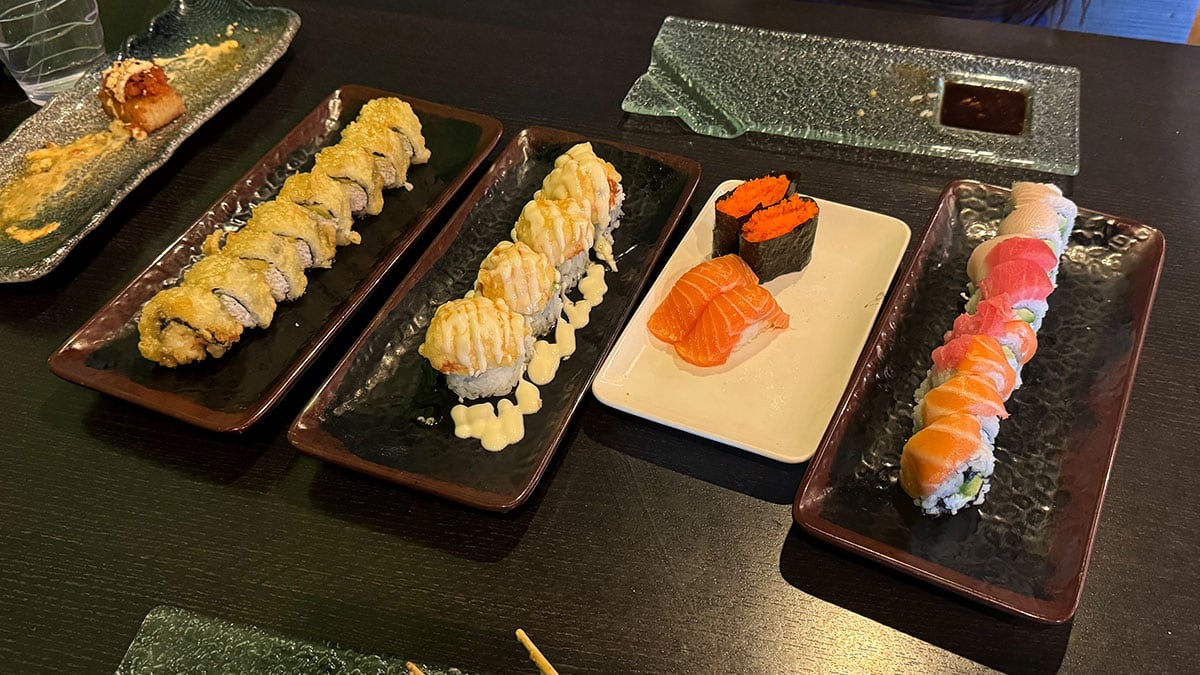 An all-you-can-eat sushi table spread at Sasa Sushi with fresh rolls, nigiri, and crispy rice dishes.