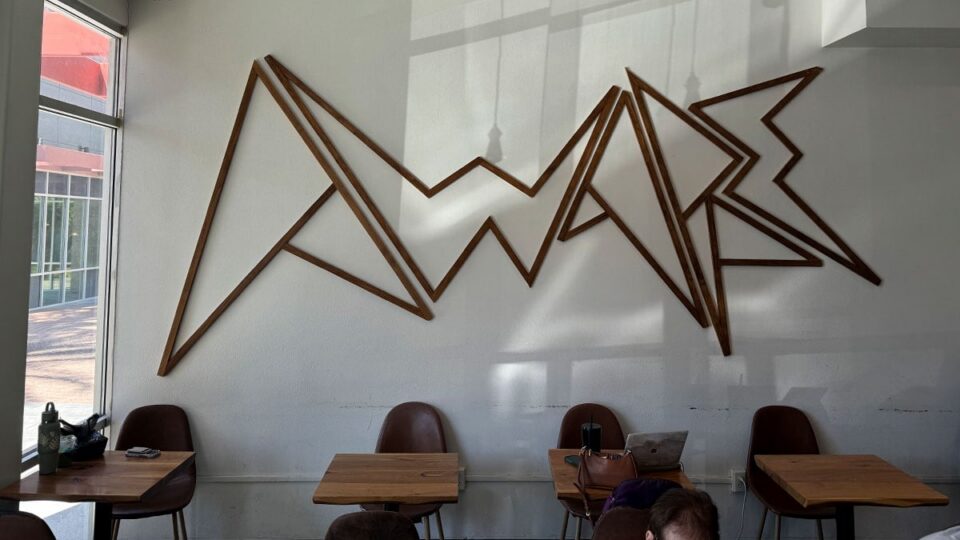 Wooden Aware Coffee logo mounted on the wall inside the Centennial Las Vegas location.