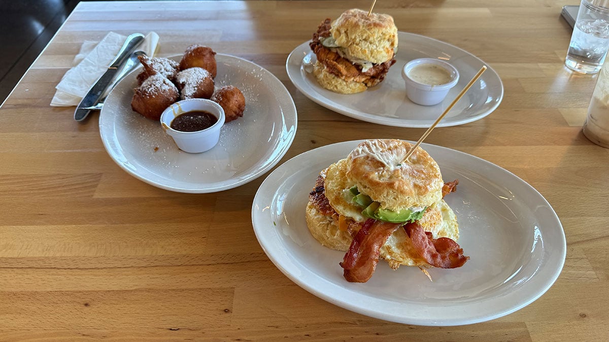 Full breakfast spread featuring biscuits, chicken sandwich, coffee, and beignets at Union Biscuit.