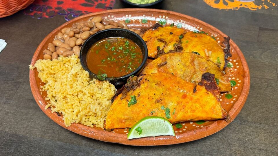 Quesabirria tacos with melted cheese and birria served with consome at Carolina's Mexican Kitchen
