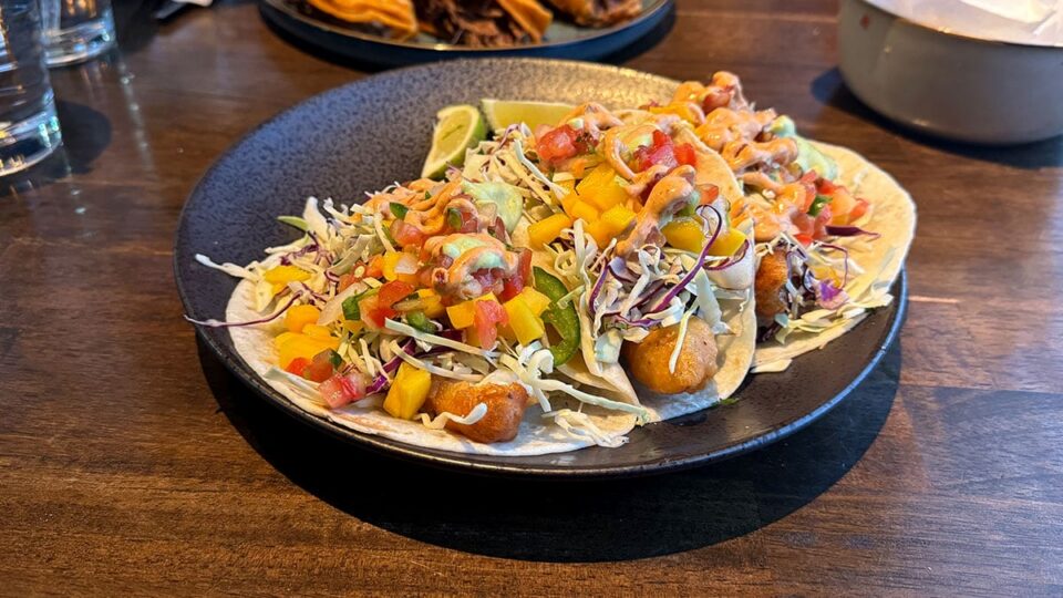 Fish tacos topped with mango, jalapeño, pico de gallo, and cabbage at Ta’Chingón.