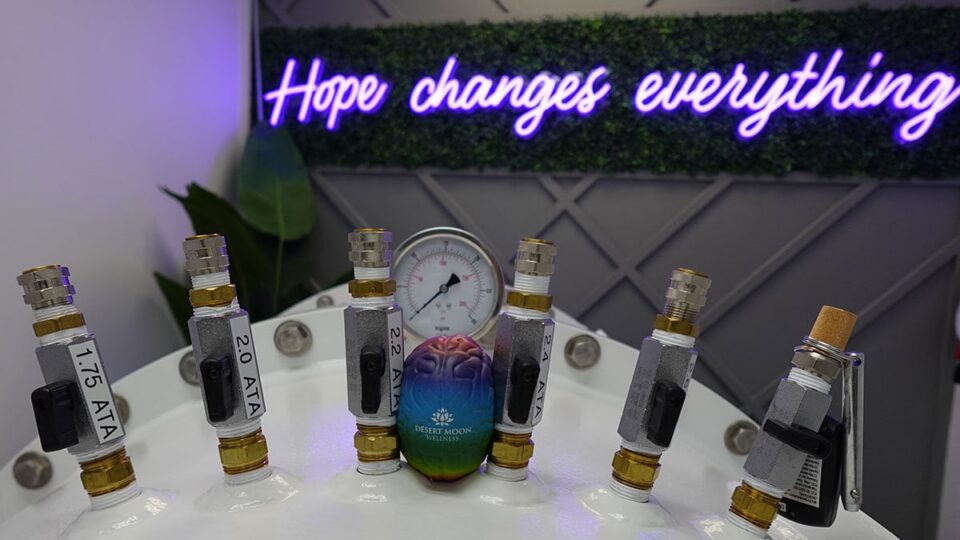 Hyperbaric Oxygen Chamber inside Desert Moon Wellness with “Hope Changes Everything” sign in the background