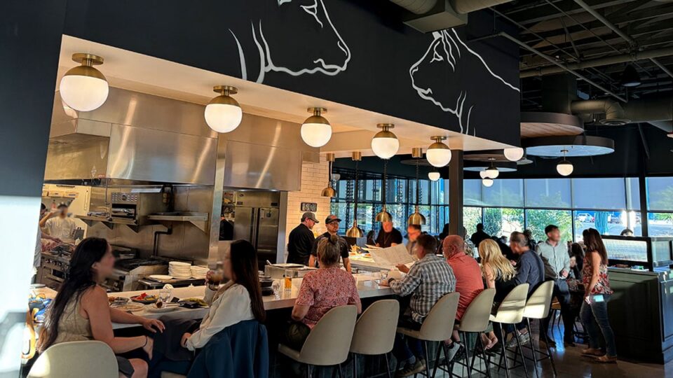 Guests enjoying dinner and cocktails at the bar inside Butcher & Thief