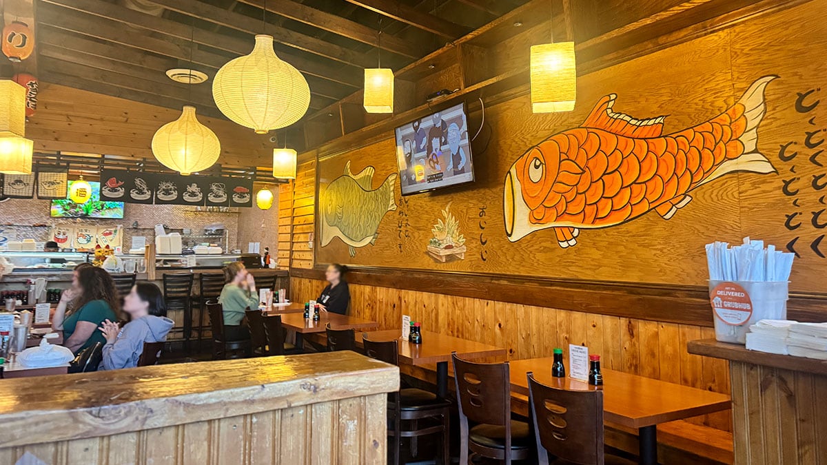 the interior dining area of sushi bomb with rustic decor and wall art