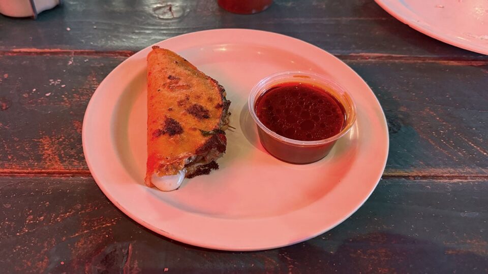 Quesabirria tacos served with consommé for dipping at Pinches Tacos.