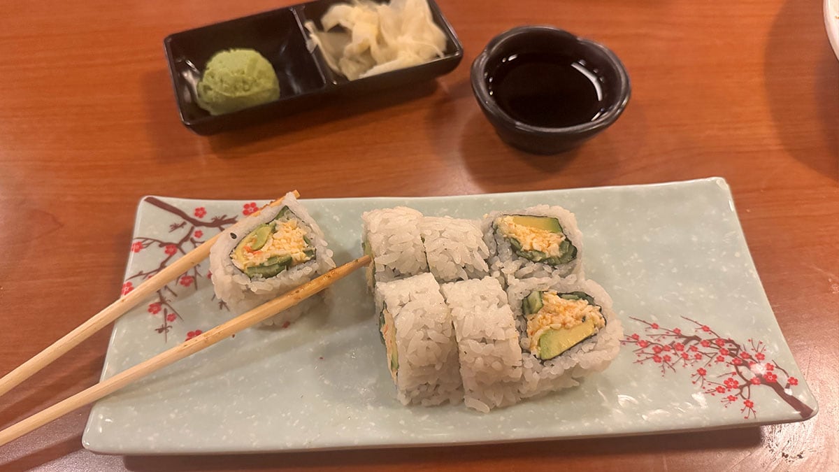 a spicy california roll drizzled with sauce and served fresh at sushi bomb