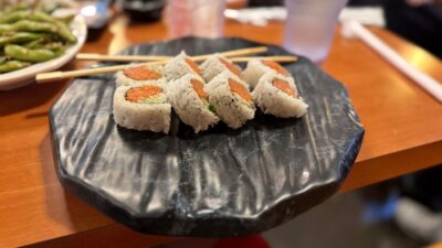 fresh spicy tuna roll topped with sauce and sesame seeds at sushi bomb