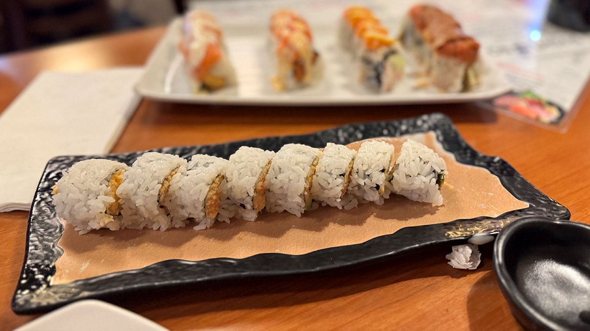 a variety of fresh all you can eat sushi rolls beautifully presented on a table at sushi bomb