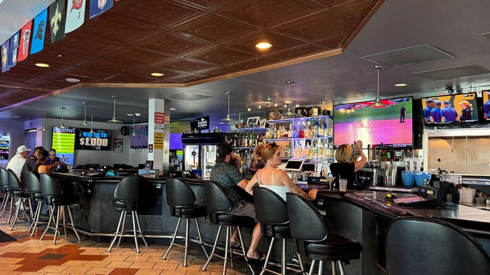 Bar area inside Sticks Tavern with TVs and sports bar atmosphere