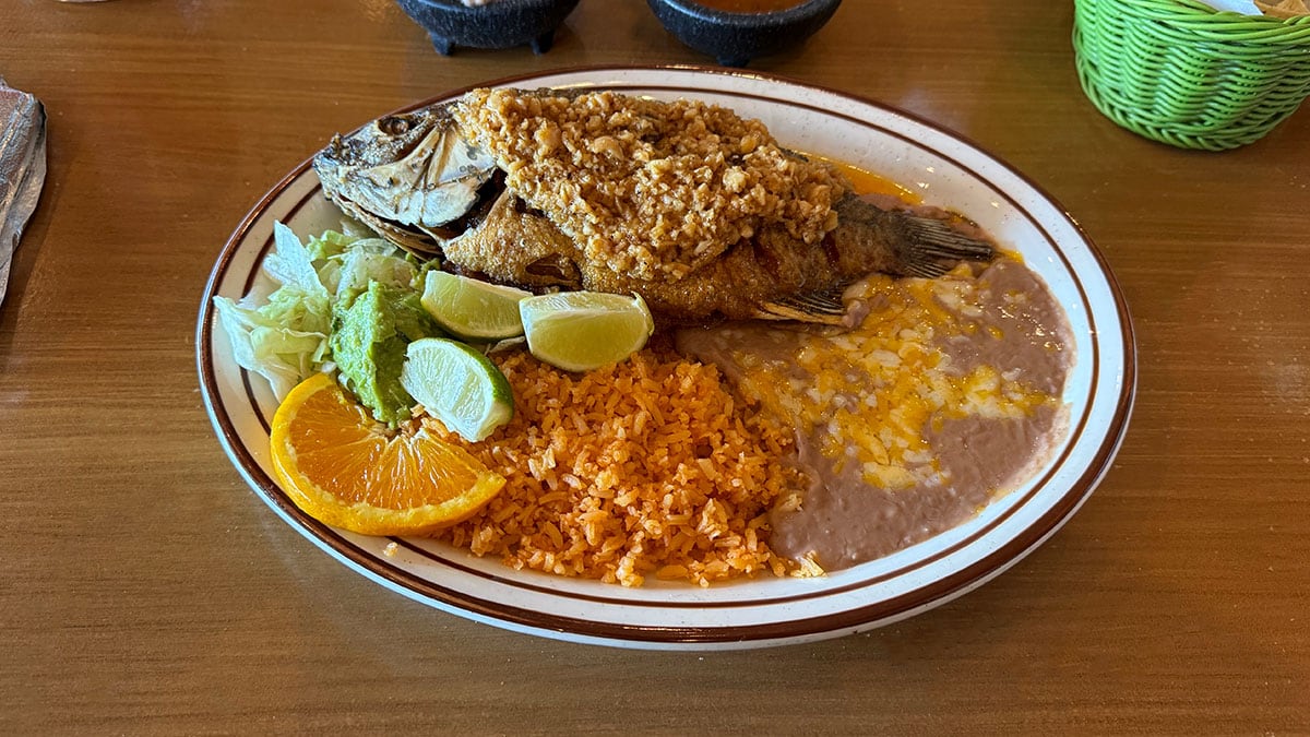 Mojarra al Mojo de Ajo whole fried fish served with rice and beans at Casa Don Juan