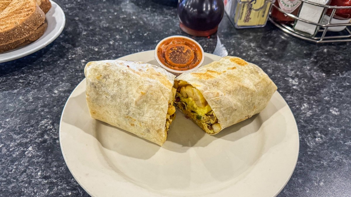 Breakfast burrito cut in half with eggs, potatoes, peppers, cheese, and salsa at Mr. Mamas Las Vegas.
