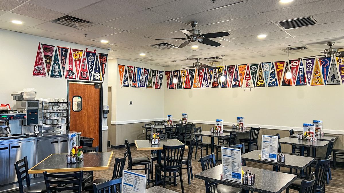 Dining room inside Mr. Mamas Las Vegas decorated with college pennants and diner seating.