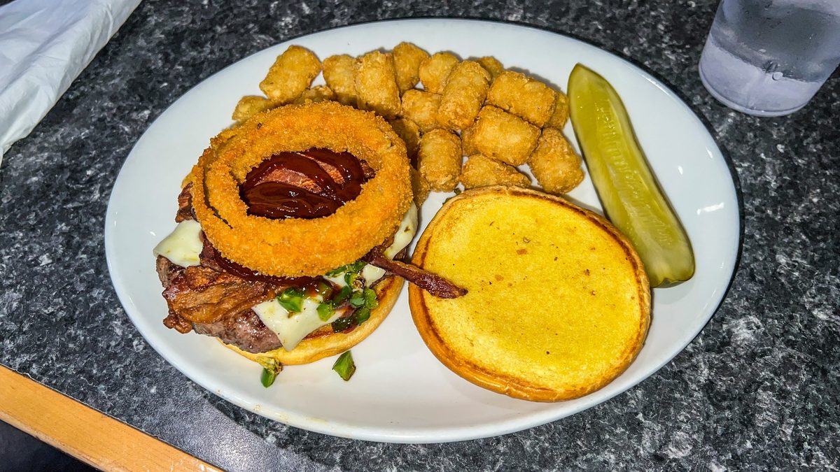 Nick’s Jalapeño Burger with onion rings, bacon, pepper jack cheese, barbecue sauce, and tater tots at Mr. Mamas Breakfast and Lunch in Las Vegas.