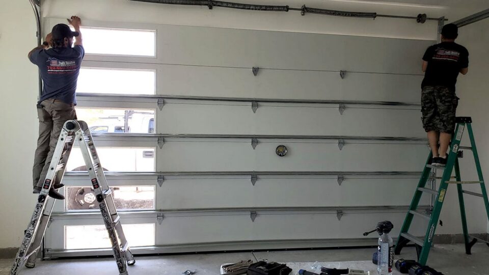Pacific Experts Technicians adjusting springs on a new garage door