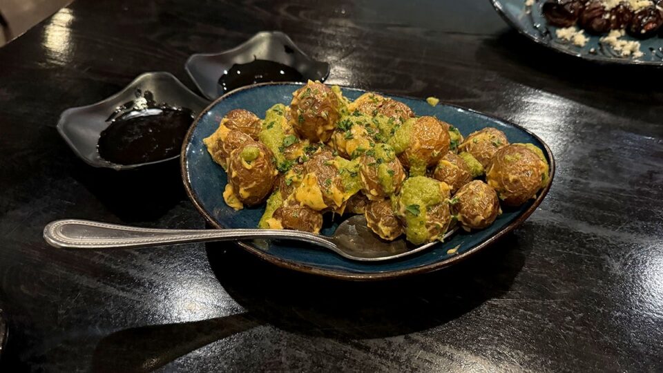 Patatas Bravas topped with chipotle aioli and poblano salsa at Tres Social Tapas.