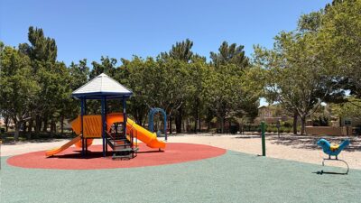 Children's playground at North Tower Park with slides, climbing structures, and shade coverings.