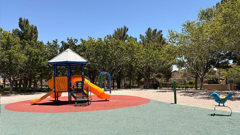 Children's playground at North Tower Park with slides, climbing structures, and shade coverings.