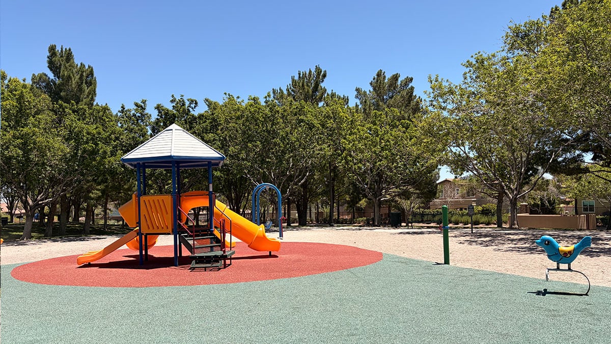 Children's playground at North Tower Park with slides, climbing structures, and shade coverings.