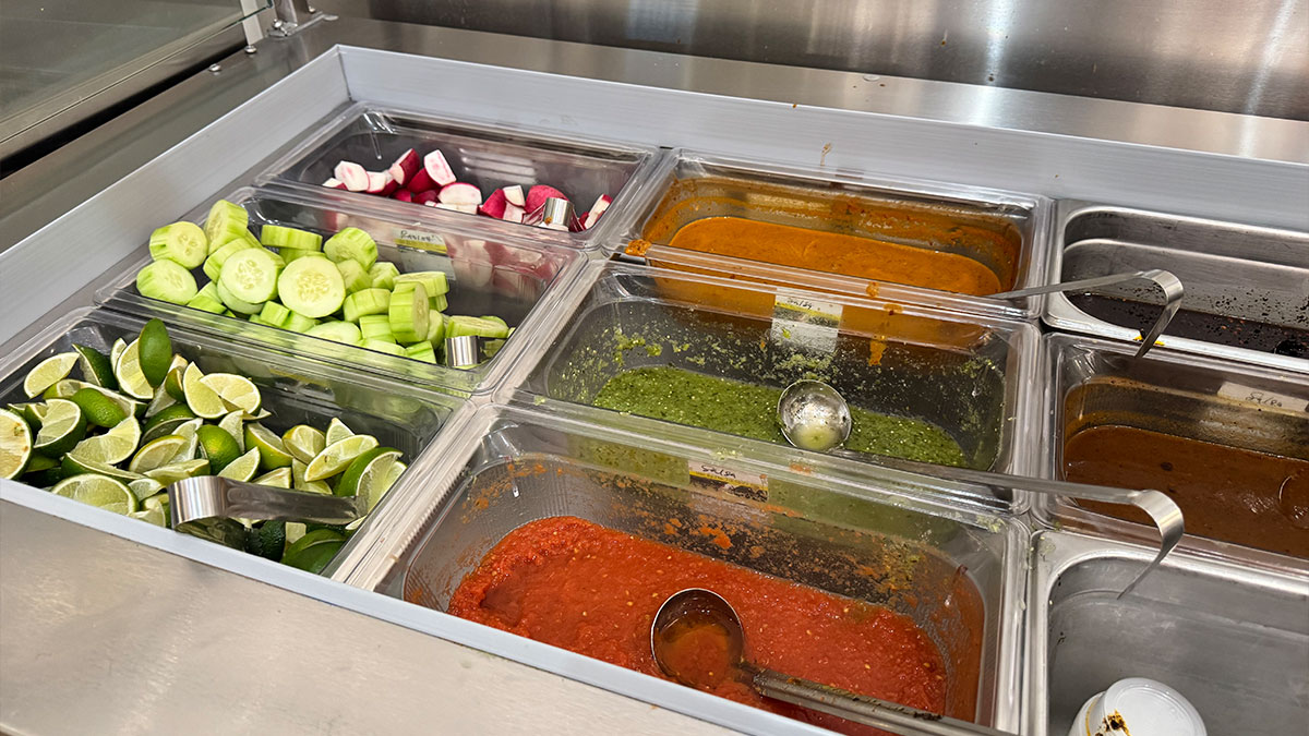 self-serve salsa bar with a variety of fresh toppings and sauces at Tacos 1986