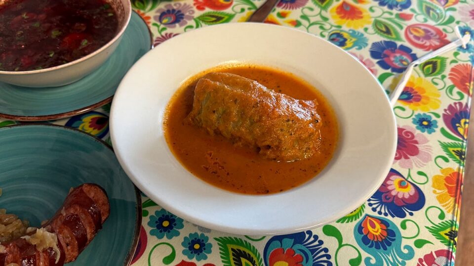 Stuffed cabbage roll filled with meat and rice and covered in a rich tomato-based sauce.