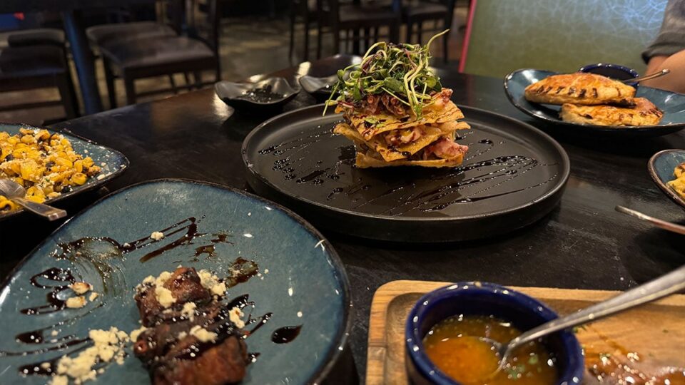 Tapas spread featuring octopus, pork belly, esquites, and Iberico dates at Tres Social Tapas.