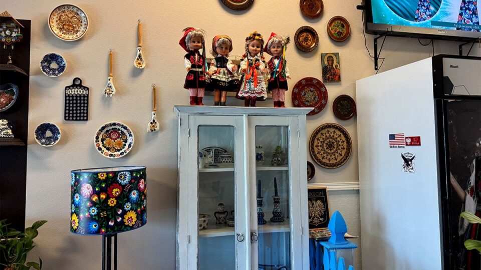 Collection of traditional Polish dolls displayed above a cabinet inside Pierogi Village.
