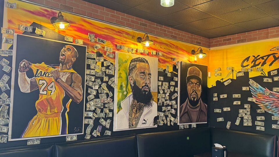 Wall art showing Kobe Bryant, Nipsey Hussle, and Ice Cube inside Dirt Dog Southwest.