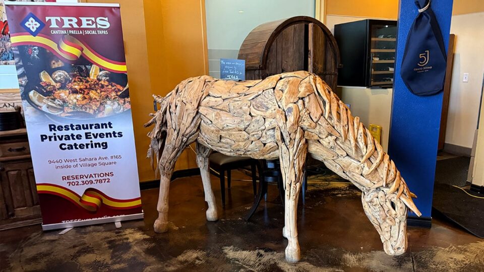 Decorative wooden burro displayed near the entrance of Tres Social Tapas restaurant.