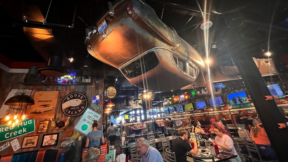 Vintage car hanging upside down from the ceiling inside Sickies Garage Burgers & Brews