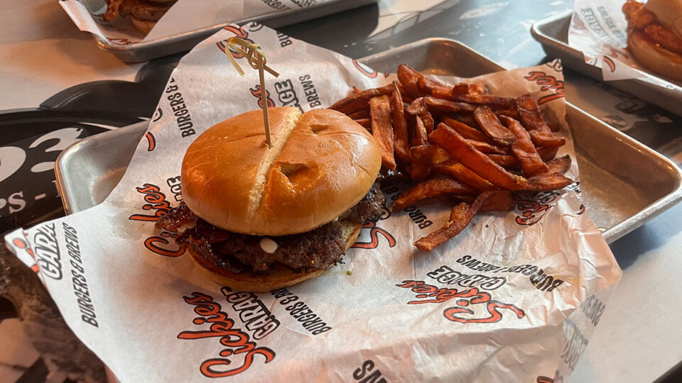 Black & Bleu Burger with Wagyu beef, bleu cheese, bourbon bacon, and fries at Sickies Garage