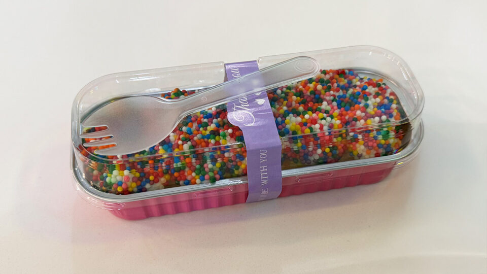 Colorful sprinkle-covered dot cake in a to-go container from Cookio Cafe in Las Vegas.