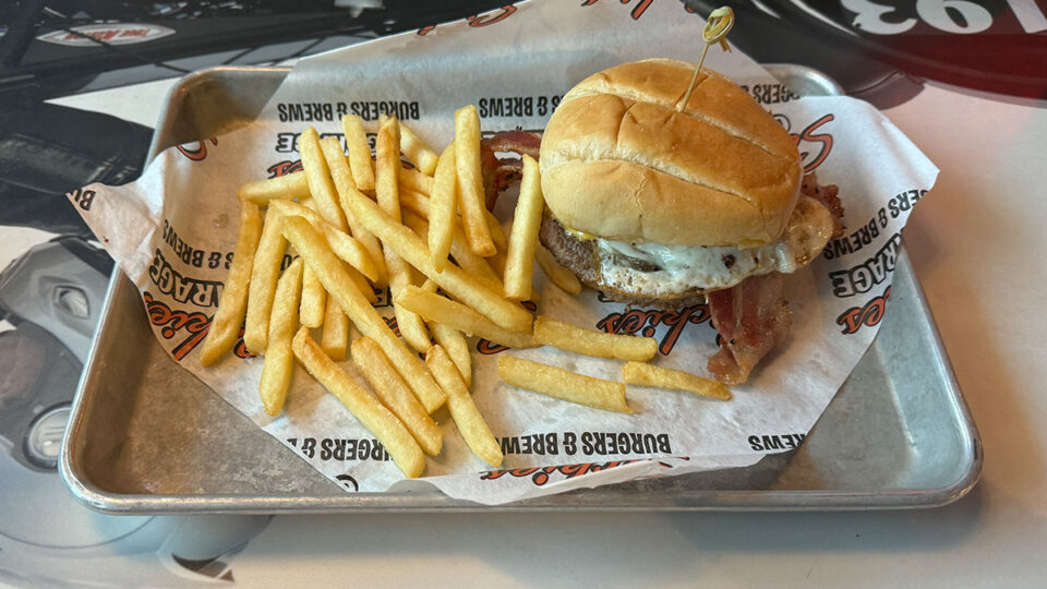 Eggstraordinary Burger topped with fried egg, bacon, and American cheese at Sickies Garage