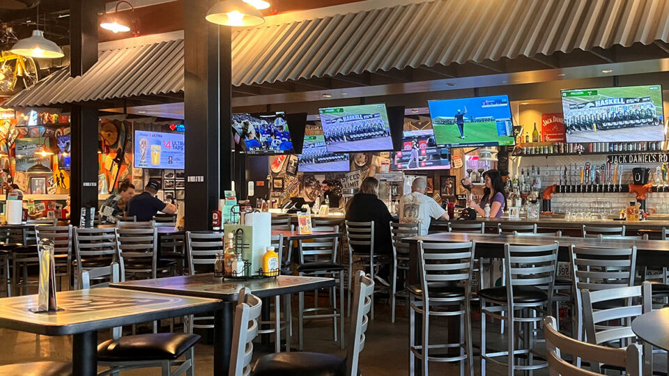 Full-service bar with high-top seating inside Sickies Garage Burgers & Brews