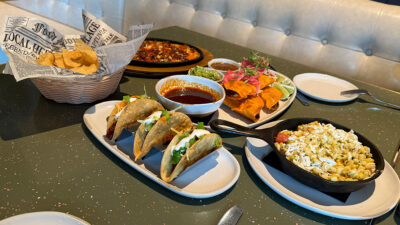 assortment of signature dishes at La Madre Canyon Grill including birriadillas, queso fundido, crunchy beef tacos, Caesar salad, roasted corn