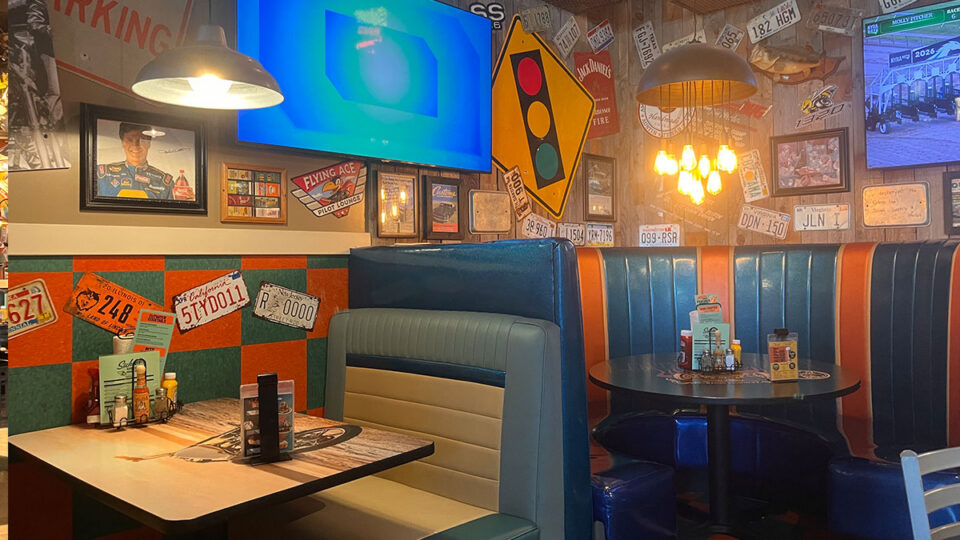 License plates, automotive memorabilia, and classic diner seating inside Sickies Garage