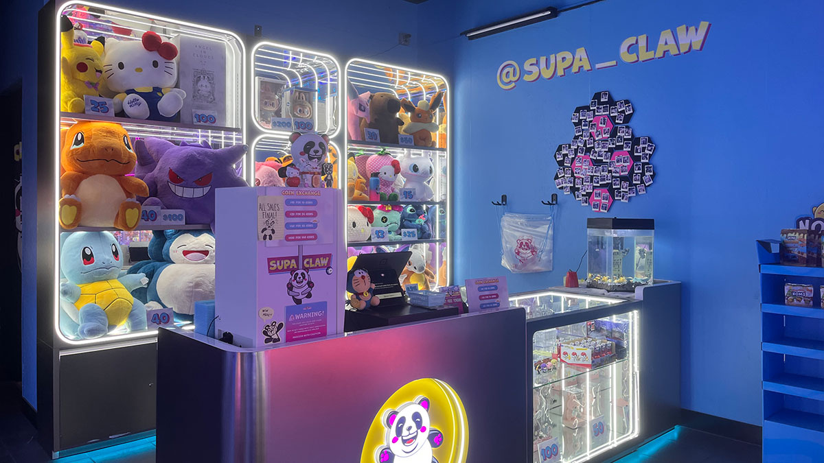 Supa Claw service counter where guests purchase credits and get assistance before playing the claw machines