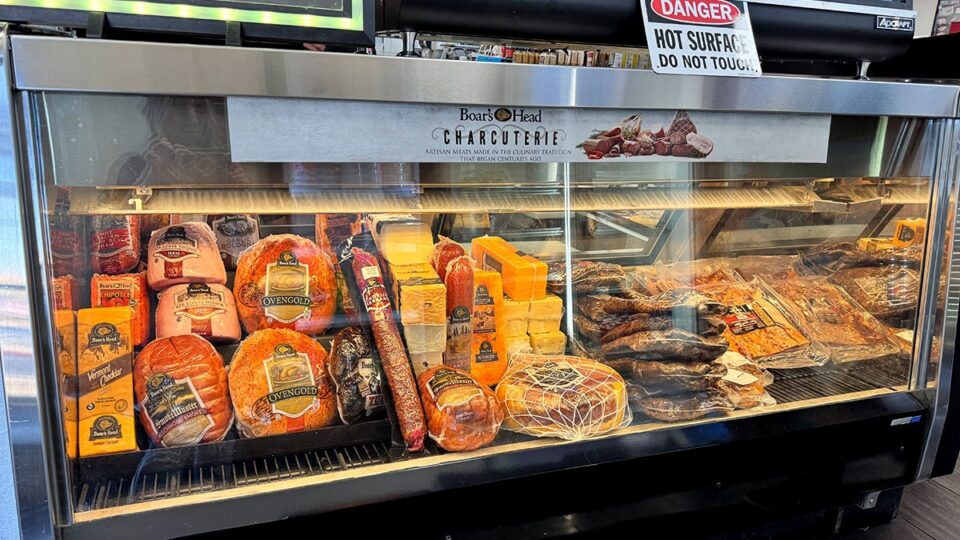 Assorted cold cuts and cheeses displayed inside the deli counter.
